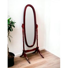 a large mirror sitting on top of a wooden stand next to a potted plant