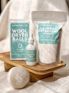 a wooden tray with two bottles and a bag of wool dryer balls on it