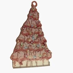 a pink christmas tree ornament with flamingos on it