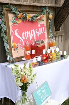 a table topped with jars filled with liquid and flowers next to a sign that says souppra