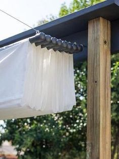 a white curtain hanging off the side of a wooden structure