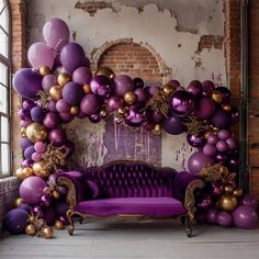 a purple couch sitting in front of a bunch of balloons