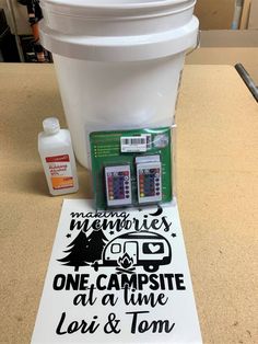 the camping sign is next to two batteries and a container with some other items on it