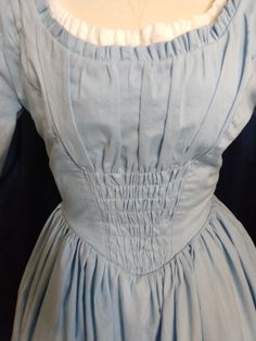 "Inspired by the live action Cinderella character. The soft, delicate dress is lightweight pale blue cotton with a gathered front panel and ruffles at the neckline. Bodice is fully lined in sturdy cotton twill. There's also a white peasant blouse insert at the neckline (not a real separate blouse). The very full skirt has six patches of pink floral appliques. It closes in back with an invisible zipper (you can choose a lace up back if you prefer). Pink apron is included. All seams are serged or Live Action Cinderella, Cinderella Characters, Delicate Dress, White Peasant Blouse, Pink Apron, 50s Dresses, Peasant Dress, Peasant Blouse, Women's Costumes