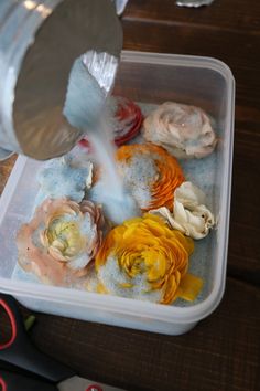 a plastic container filled with lots of different colored flowers