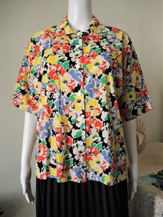 Beautiful Vintage short sleeve blouse from the 1980s. Comfortable cotton fabric with a vibrant summer floral pattern. Straight, boxy cut, wide sleeves, button down. Looks great with a pair of jeans and flatform sandals. BRAND: C&A ERA: 1980s COLOR: White, black, green, yellow, red, lilac FABRIC: 100% cotton SIZE: No size tag, fits best size M to small L (or S for a more oversized fit) - please check measurements below for reference MEASUREMENTS: Pit to pit 54cm, total length 60cm CONDITION: Lilac Fabric, Printed Denim Jacket, Flatform Sandals, Duffle Coat, Vintage Short, Printed Denim, Cotton Blouse, Blouse Shirt, Vintage Shorts