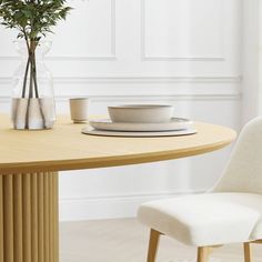 a table with a bowl, plate and vase on it