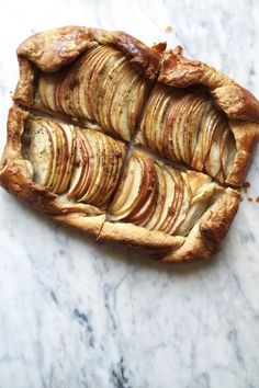 an apple pie is cut in half on a marble surface