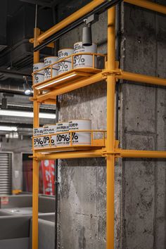 some yellow shelves with signs on them in a warehouse or office building that is under construction