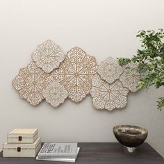 a wooden table topped with a vase filled with flowers next to a wall mounted art piece