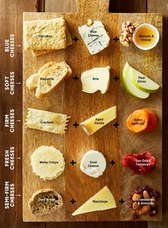 a wooden cutting board topped with different types of cheeses and crackers on top of it