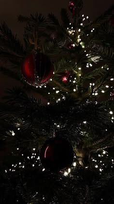 a lit up christmas tree with ornaments on it