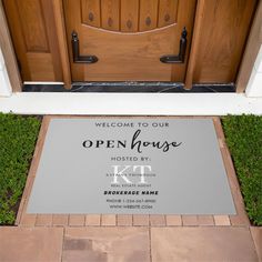 a welcome mat is placed in front of the entrance to an open house with wooden doors