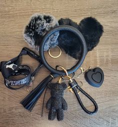 several items are laid out on a wooden surface, including gloves and keychains