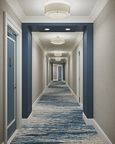 a long hallway with blue and white carpeting leading to two doors on either side