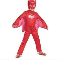 a child in a red costume with pink wings on his head and chest, standing up