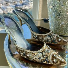 Elevate Your Look With These Gorgeous Gold Renee Caovilla Slingback Pumps. The Pointed Toe And Crystal Embellishments Add A Touch Of Elegance, Perfect For Any Formal Occasion Or Wedding. These Pre-Owned Heels Are In Excellent Shape And Will Fit A Us Shoe Size Of 8.5. The Vintage Style Of These Shoes Make Them A Unique Addition To Any Wardrobe, Especially For Those Who Appreciate High-End Designer Brands. Don't Miss Out On The Opportunity To Add These Stunning Heels To Your Collection Today. (Worn Once To My Daughter’s Wedding) Retail Value $1110 Gold Embellished Slingback Pumps For Formal Occasions, Gold Embellished Slingback Pumps For Evening, Luxury Embellished Slingback Pumps For Gala, Embellished Slingback Pumps For Formal Occasions, Embellished Slingback Heels For Gala, Elegant Embellished Ankle Strap Heels, Elegant Crystal-embellished Heels For Dinner, Glamorous Embellished Slingback Pumps For Gala, Elegant Gold Slingback Pumps For Evening