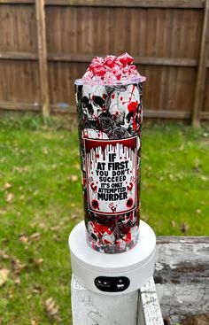 a cooler filled with lots of candy sitting on top of a wooden table in front of a fence