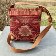 "Boho Red and Brown Vegan crossbody or shoulder bag. A wonderful everyday bag. A small bag to just carry what you really need. The outside has a deep zipper pocket on each side .   Top zip opens to roomy interior. Strap is soft Cotton web material in Golden Brown and adjustable to shoulder bag or crossbody length.  Great as a travel purse-very light weight. 7\" wide 8 1/2\"deep 1 1/2 bottom The Oriental Tapestry is Upholstery Fabric imported from Turkey. The Brown Stripes Fabric was rescued from Fabric Crossbody Bag, Corps Idéal, Bag Minimalist, Upcycled Fabric, Stripes Fabric, Medicine Bag, Red Boho, Travel Purse, Holiday Shopping