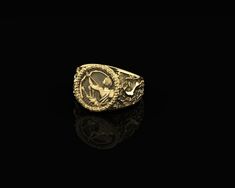 a gold ring with an image of the virgin mary and child jesus on it, against a black background