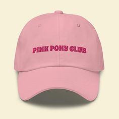 A classic hat with "Pink Pony Club" embroidered on the front. The hat has a low profile with an adjustable strap and curved visor. * 100% chino cotton twill * Unstructured, 6-panel, low-profile * 6 embroidered eyelets * 3 ⅛" (7.6 cm) crown * Adjustable strap with antique buckle This product is embroidered for you as soon as you place an order, which is why it takes us a bit longer to deliver it to you. Making products on demand instead of in bulk helps reduce waste and overproduction, so thank you for helping Sapphic Life Guide contribute to sustainable fashion. Trendy Adjustable Cap, Trendy Adjustable Fit Cap, Pink Trucker Hat With Curved Visor, Trendy Pink Trucker Hat With Curved Visor, Adjustable Trucker Hat With Embroidered Logo And Visor, Trendy Visor Hat With Embroidered Logo, Trendy Baseball Cap With Curved Brim And Adjustable Fit, Trendy Baseball Cap With Adjustable Fit, Trendy Adjustable Baseball Cap With Curved Brim