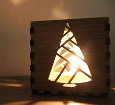 a wooden box with a lit candle in the shape of a christmas tree