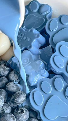 blue liquid being poured onto an egg in a bowl filled with eggs and other items