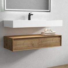 a bathroom sink with a mirror above it and towel on the shelf next to it