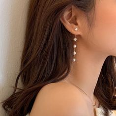 a close up of a person wearing some kind of earring with pearls on it