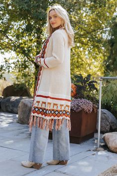 Our Beige Tribal Print Fringe Duster Cardigan is perfect for any fall occasion! This duster-length cardigan showcases a bold tribal print and a fringe hem for added style. It offers both comfort and a touch of bohemian flair, making it perfect for layering throughout the season. Layer it over a basic top and pair with jeans, ankle booties, and matching accessories to complete the look. Bohemian Fall Outerwear With Tassels, Bohemian Fringe Outerwear For Fall, Beige Fringe Cardigan For Fall, Fringe Cardigan For Fall, Fringe Cardigan For Fall Layering, Fall Beige Fringe Cardigan, Fall Fringe Cardigan, Bohemian Fall Cardigan With Tassels, Bohemian Cardigan For Fall Layering