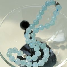 This charming necklace features a combination of ocean blue chalcedony beads that exudes freshness and tranquility. The beads are delicately strung together to create an elegant composition that evokes a feeling of natural beauty and serenity. The necklace is accented with a magnetic clasp that ensures easy wearing and secure closure, adding to its charm. Metal: 18K Recycled Sterling Silver Plated On Brass Gemstone: Aquamarine 10mm Diameter: 450mm Weight: 66g Blue Beaded Chalcedony Necklace, Elegant Light Blue Necklaces With Natural Stones, Elegant Light Blue Necklace With Natural Stones, Elegant Light Blue Single Strand Beaded Necklace, Elegant Amazonite Bead Necklaces, Light Blue Polished Beads Necklace For Gift, Elegant Amazonite Beaded Necklace, Blue Chalcedony Gemstone Bead Necklaces, Blue Chalcedony Bead Necklaces