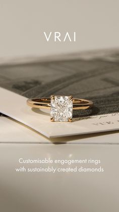 a diamond ring sitting on top of a piece of paper with the words vrai written below it