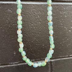 Searching for an iconic summer necklace? Look no further! Don't just take a dip in the sea. Dive in with our Ocean Eyes Necklace! Let these dreamy blue-green swirled recycled matte glass beads transport you to the depths of the ocean. Whether it's center stage or the base for layering, you'll fall in love with this versatile statement necklace. 7mm recycled glass beads, hand-made by the Krobo Tribe of Ghana, West Africa 4mm smooth roundel beads in 14kt gold or sterling silver. Adjustable chain l Adjustable Recycled Glass Necklaces For Beach, Beach Glass Jewelry Hand-strung, Adjustable Beaded Recycled Glass Necklace, Adjustable Green Recycled Glass Necklace, Single Strand Glass Beaded Necklace For Beach, Everyday Green Jewelry With Large Beads, Glass Bead Necklaces For Beach, Glass Necklaces With Tiny Beads For The Beach, Glass Tiny Beads Necklace For Beach