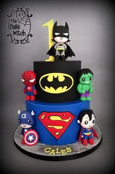 a birthday cake with batman, superman and spiderman figures on the top tiers