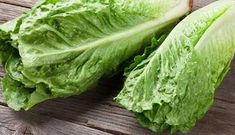 two lettuce halves sitting on top of a wooden table