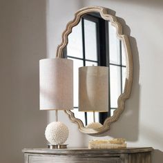 a table with a lamp and mirror on it