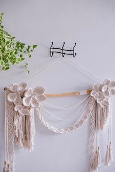 a white wall hanging with tassels and flowers