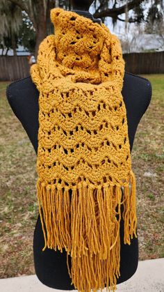 a yellow crocheted scarf on top of a mannequin