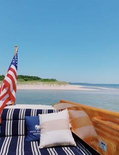 an american flag is on the back of a boat with blue and white striped sheets