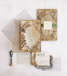 the wedding stationery is made up of paper and gold foil, with palm leaves on it