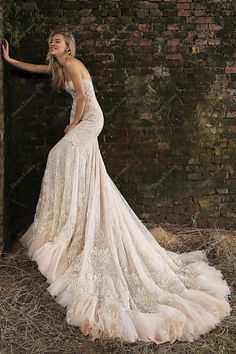 a woman in a wedding dress leaning against a brick wall with her hand on the door