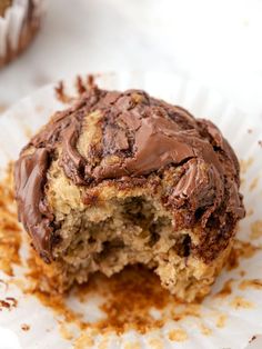 a chocolate frosted muffin on top of a paper plate