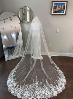 a wedding veil sits on the floor in front of a mirror