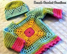 a crocheted baby outfit and hat on a bed