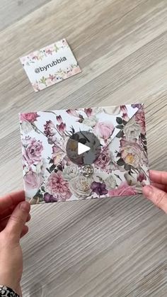 someone holding up a card with flowers on it