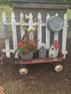 a wheelbarrow filled with flowers and bird houses