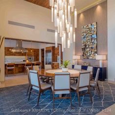 a dining room table with chairs and a chandelier hanging from it's ceiling