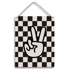 a black and white checkered wall hanging sign with a peace hand on the front