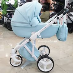 a baby stroller is on display in a store, with other items behind it