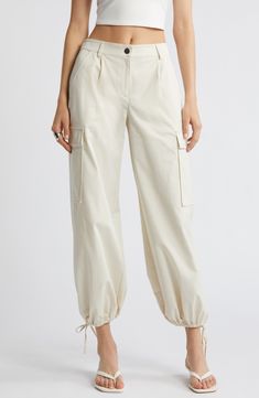 Drawstring ankle-length hems add versatility to these utilitarian cargo pants fashioned with recycled fibers. 28" inseam; 14" leg opening; 11 1/2" front rise; 13 1/2" back rise (size medium) Zip fly with button closure Front slant pockets; cargo flap-patch pockets Drawstring ankle hems 65% recycled polyester, 35% polyester Machine wash, tumble dry Imported Beige Relaxed Fit Cargo Jeans For Spring, Spring Beige Cargo Pants With Patch Pockets, Cream Straight Leg Utility Cargo Pants, Beige Cargo Jeans With Cargo Pockets For Spring, Utility Cotton Cargo Pants With Cuffed Ankles, Beige Cargo Pocket Ankle-length Pants, Cream Cotton Cargo Pants For Work, Beige Cargo Ankle-length Pants, Beige Parachute Pants With Tapered Leg And Side Pockets